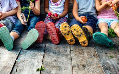 Becoming Sons and Daughters of God; photo of children sitting on a wooden deck as a figurative illustration of children of God