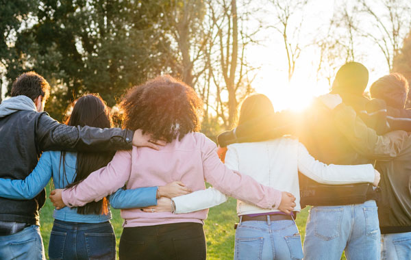 Group of young people arm-in-arm facing away