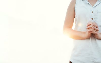 Photo of the torso of a woman standing with hands clasped to illustrate the article about 